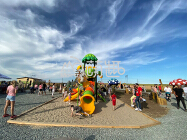 a plastic outdoor playground in one amusement park, many people around.